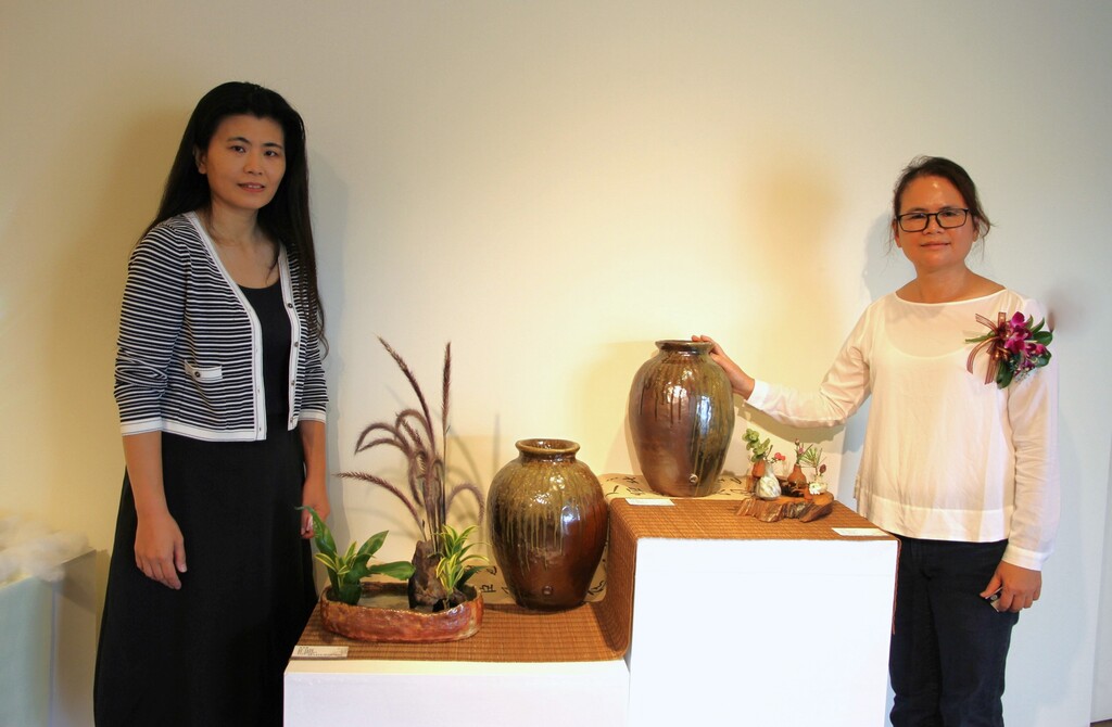 元培茶陶文創學程進二技畢業生李幸娥(右)也是新竹市花藝協會總幹事,作品以花器為主,協會理事長羅怡敏特來欣賞
