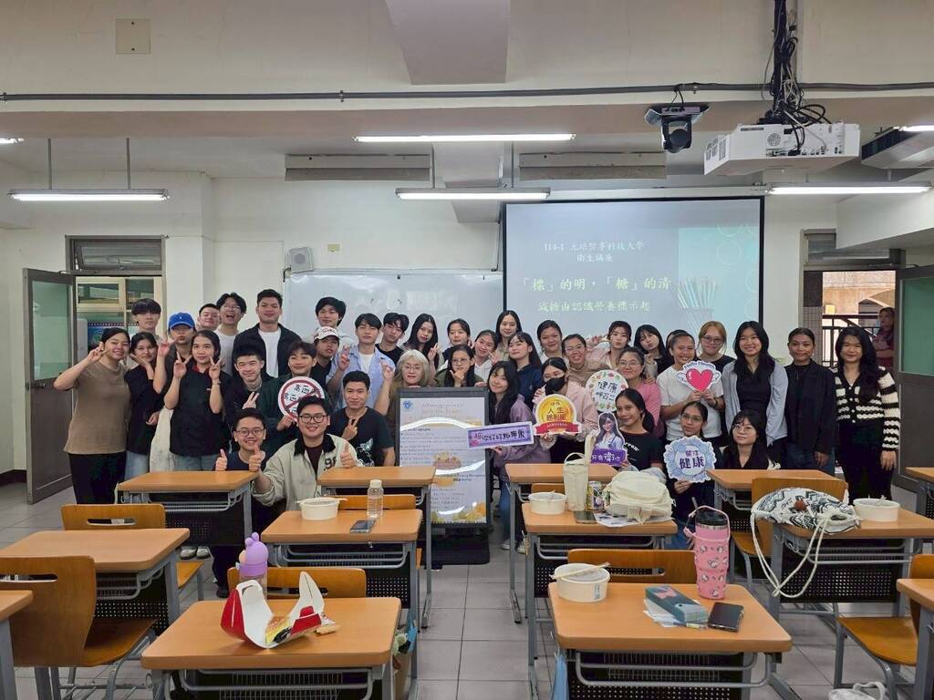 同學手持健康飲食宣導手拿牌，與元培餐飲管理系徐瑞蓮老師(中間手比YA)及活動海報一同開心合影，為本次活動留下充滿活力的畫面。圖片