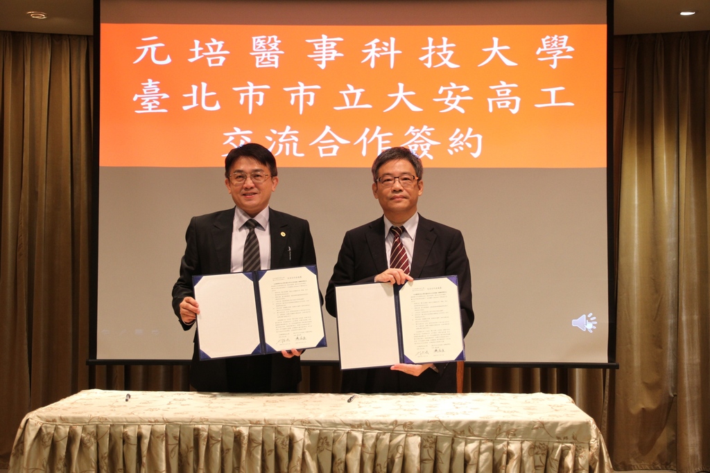元培醫事科大校長林志城(右)與台北大安高工校長楊益強(左)代表兩校簽訂合作意向