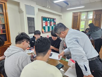 林易璁講師(右)引導元培學生分組撰寫行動企劃書圖片