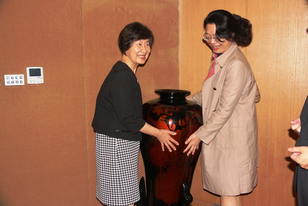 台灣大學名譽教授孫璐西抬起看起來很重的漆器花瓶