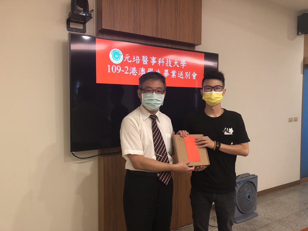 元培校長林志城(左)頒贈畢業禮物給生技製藥系吳鉅鴻同學