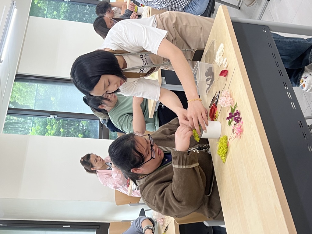 元培舉辦母親節手作花活動，講師指導學生製作花禮。圖片