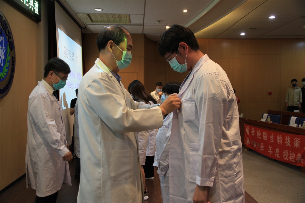 元培醫技系主任陳有任(左)等師長一一為即將進入醫院實習的學生授袍