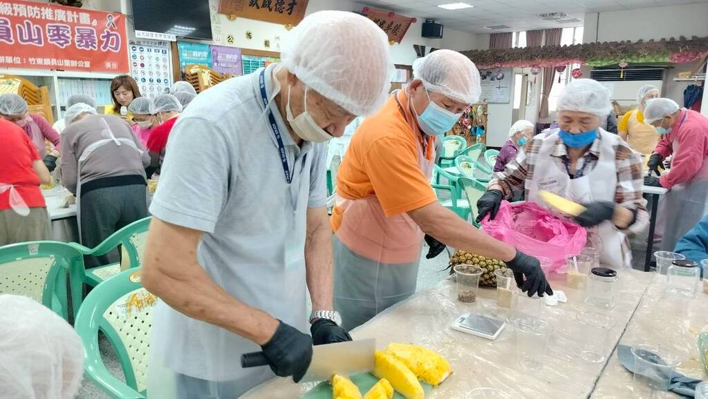 社區長輩在元培食科系師生協助下分切鳳梨圖片