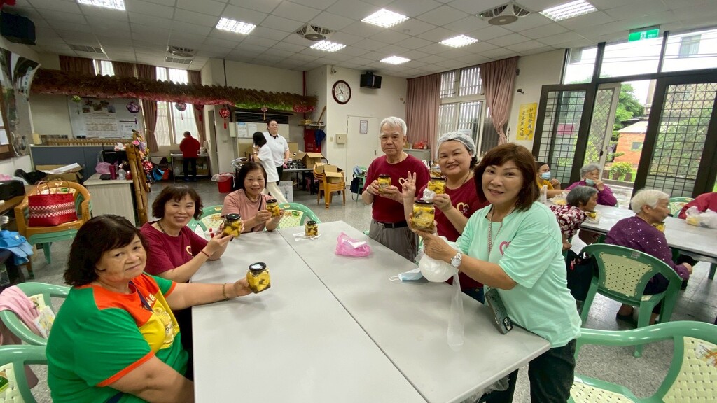 社區長輩開心展現在元培食科系師生協助製作完成的醃漬鳳梨成果圖片