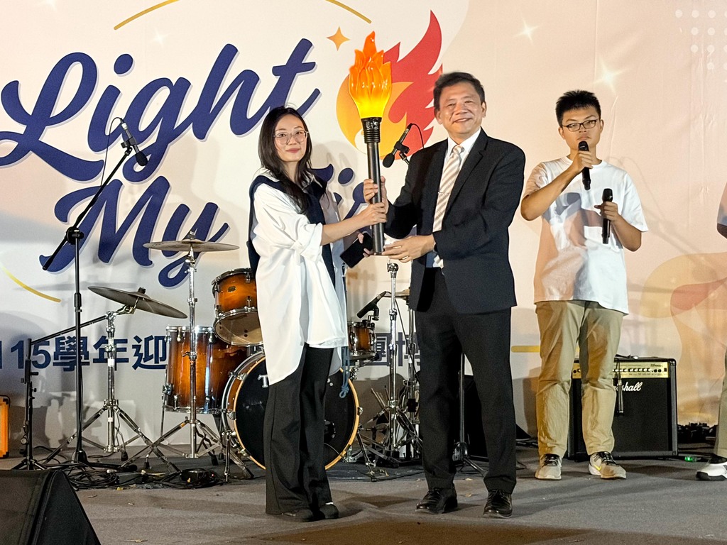 王綮慷校長（右）將象徵使命與知識的火炬傳遞給學生會會長裴阮嵐瓊同學，象徵「窮理研幾」精神的代代相傳與學生自治的延續。圖片
