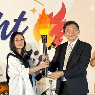 王綮慷校長(右)將象徵使命與知識的火炬傳遞給學生會會長裴阮嵐瓊同學,象徵「窮理研幾」精神的代代相傳與學生自治的延續。